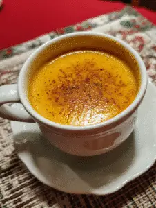 Creamy butternut squash soup topped with cinnamon in ceramic bowl.